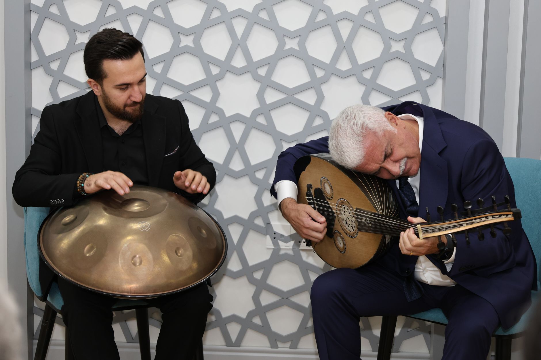 Two musicians playing oud and handpan in a cozy indoor setting, conveying cultural richness and musical harmony. — 4 Tricks I