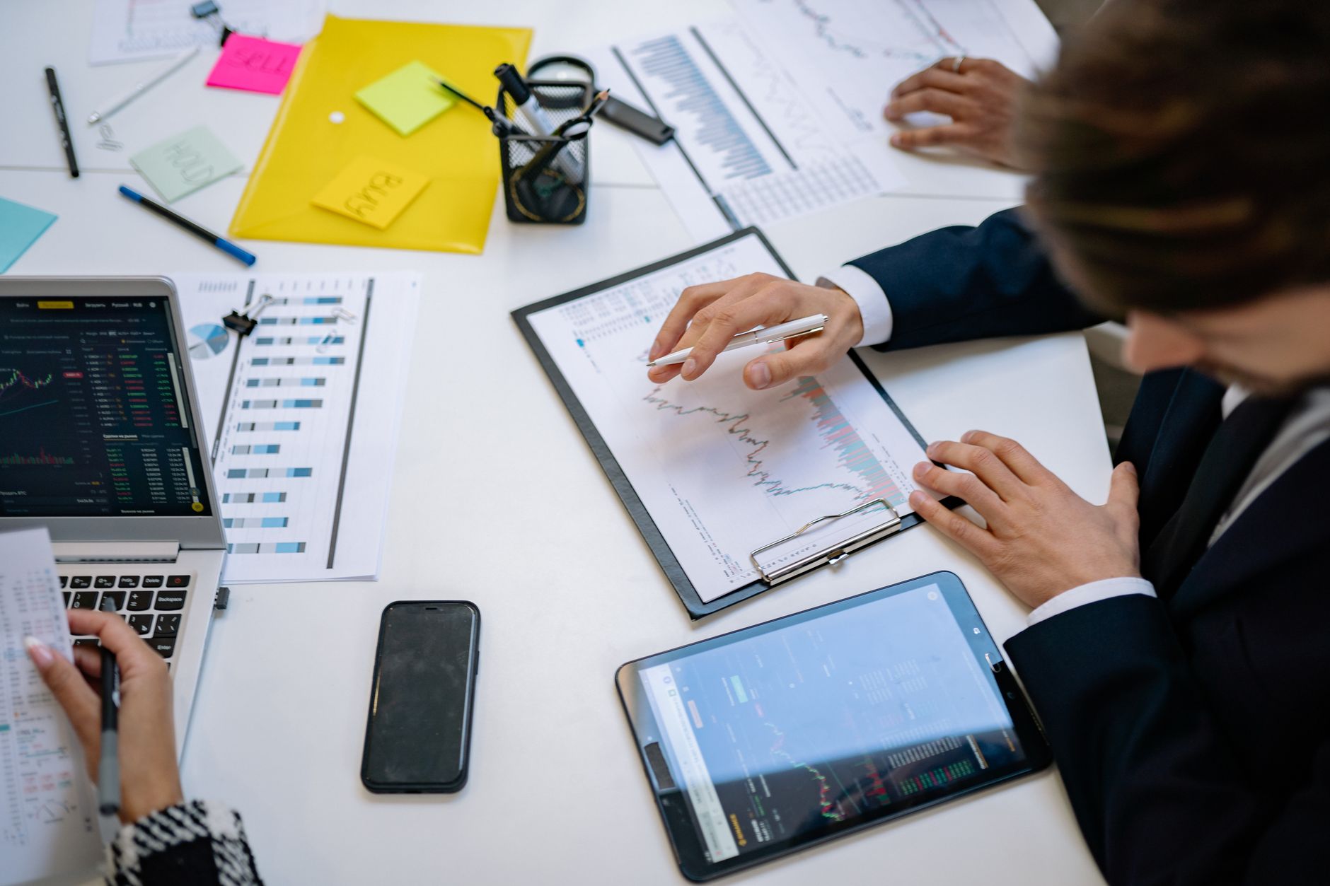Team reviewing financial charts and digital data on tablets in an office setting. — Determining Liability in a Colorado Sprin