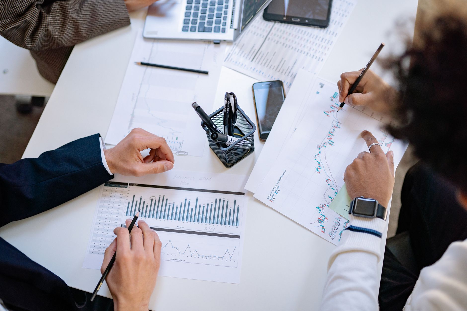 Business team analyzing financial charts and graphs during a collaborative meeting. — Different Ways Of Doing Free Background