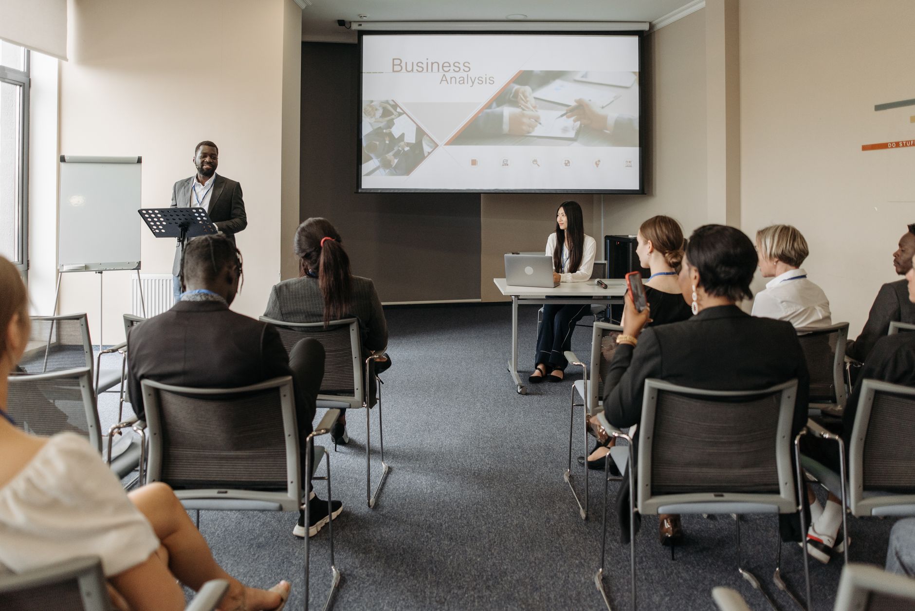 A diverse group of adults attending a presentation in a conference room setting. — Forex market a place to earn money:
