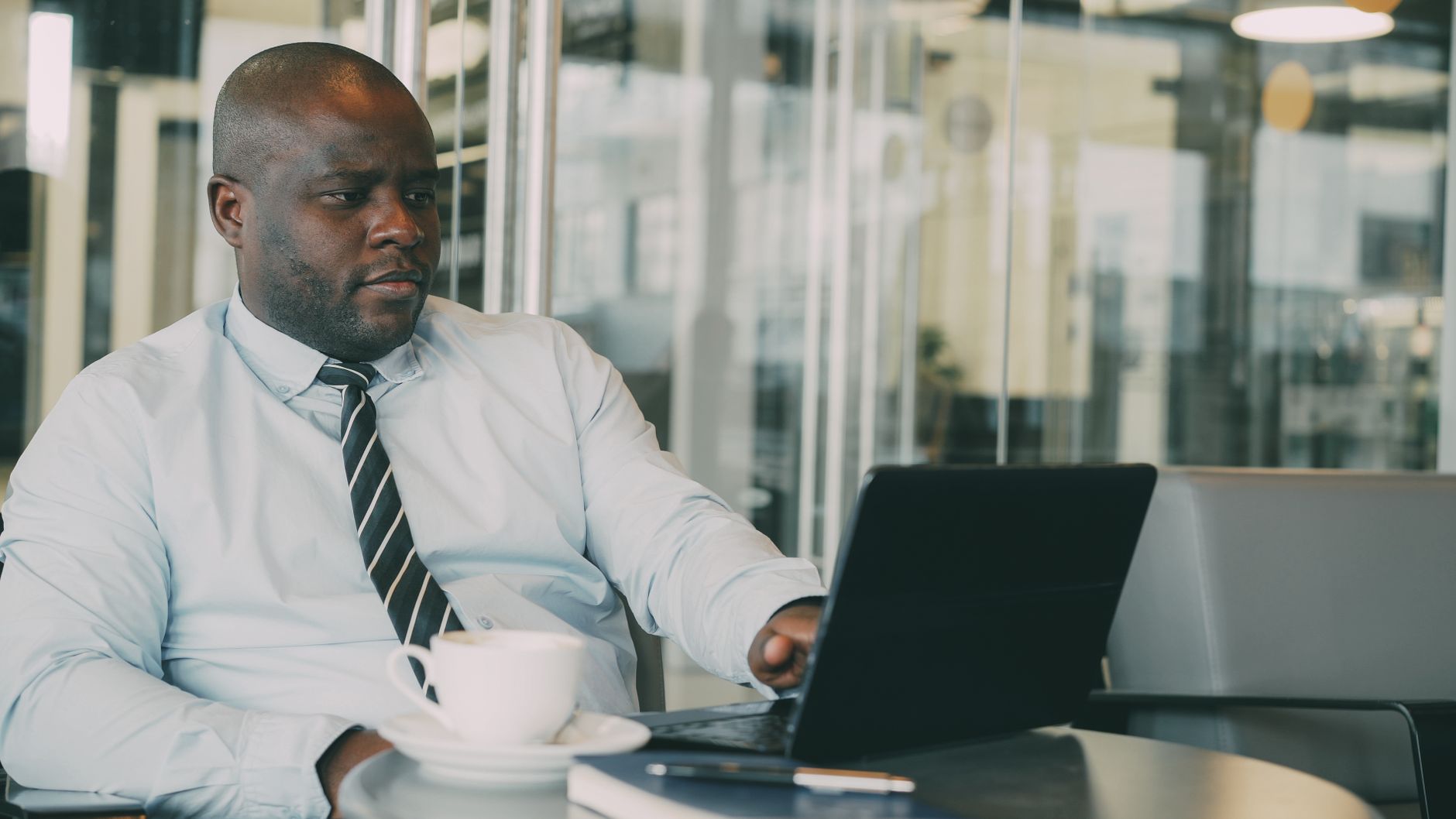 Focused businessman uses laptop in stylish cafe, sipping coffee. Perfect for business or lifestyle themes. — Gain Followers O