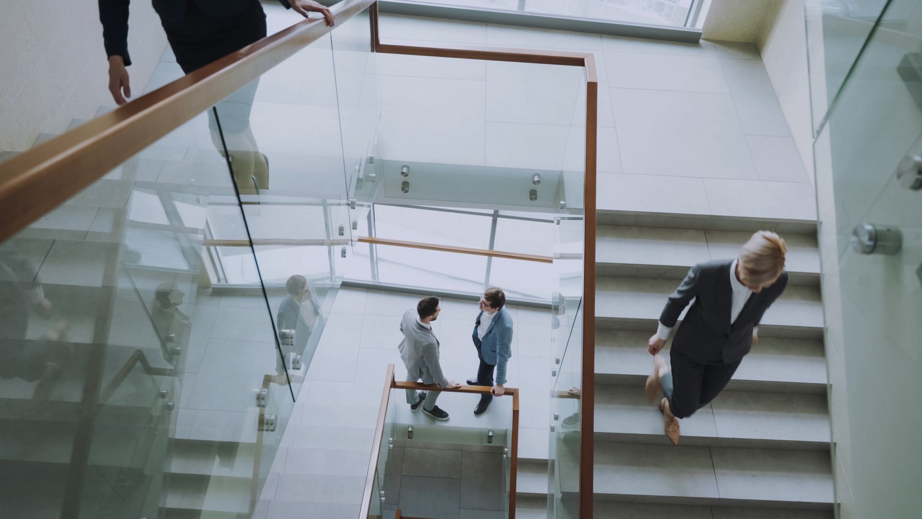 Aerial view of professionals conversing in a glass staircase in a modern office. — Getting A Competent Real Estate Agent When