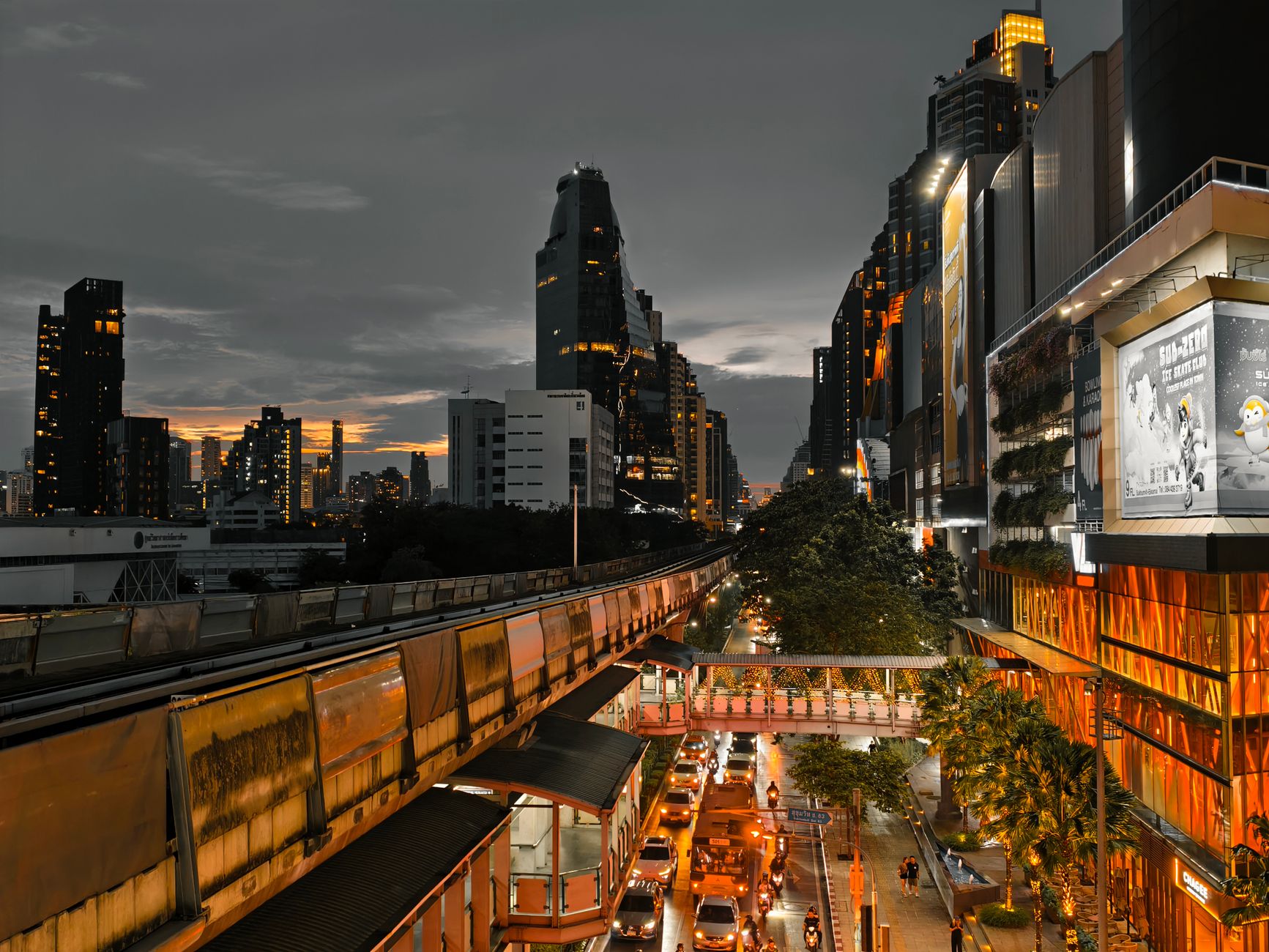 Cityscape at twilight showing busy traffic, skyscrapers, and an elevated train line in an urban setting. — How Colorado Laws