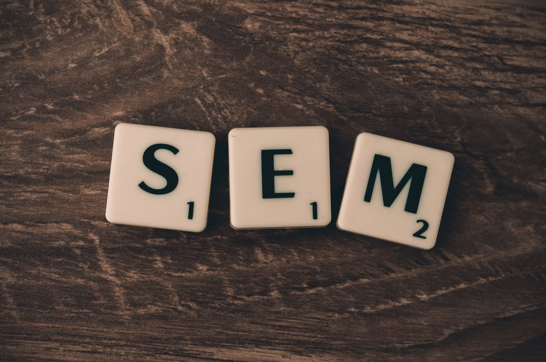 Wooden background with letter tiles spelling SEM, representing search engine marketing. — How Social Media Marketing Can Chan
