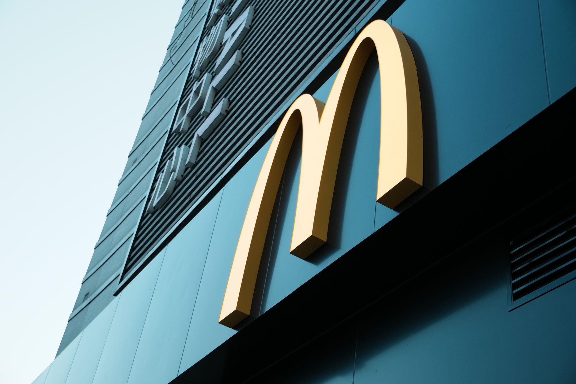 Large fast food restaurant golden arch sign on a modern building facade. — How to approach a brandname Identity Crisis