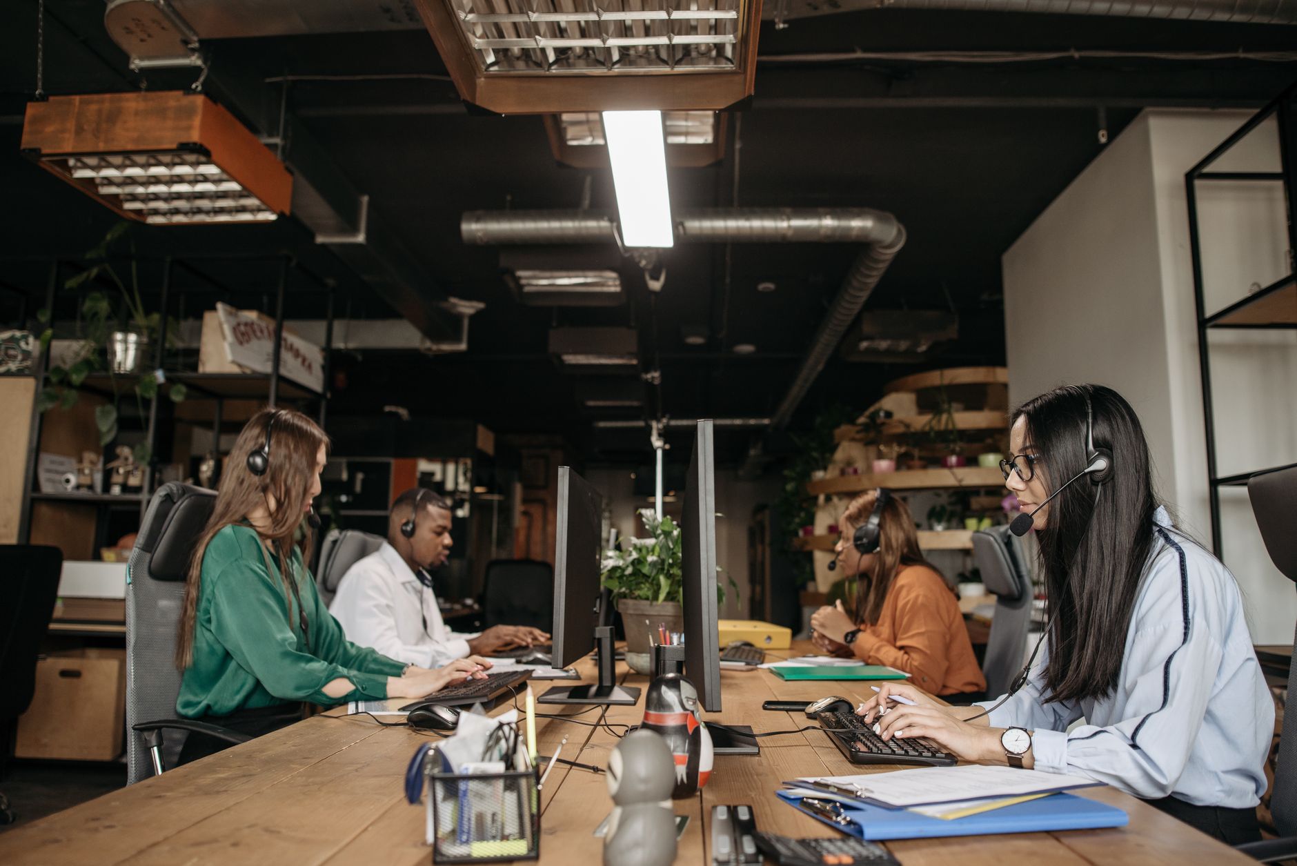 A mixed-gender team working at a call center desk, focusing on customer service tasks. — MetaTrader 4: Trade efficiently with