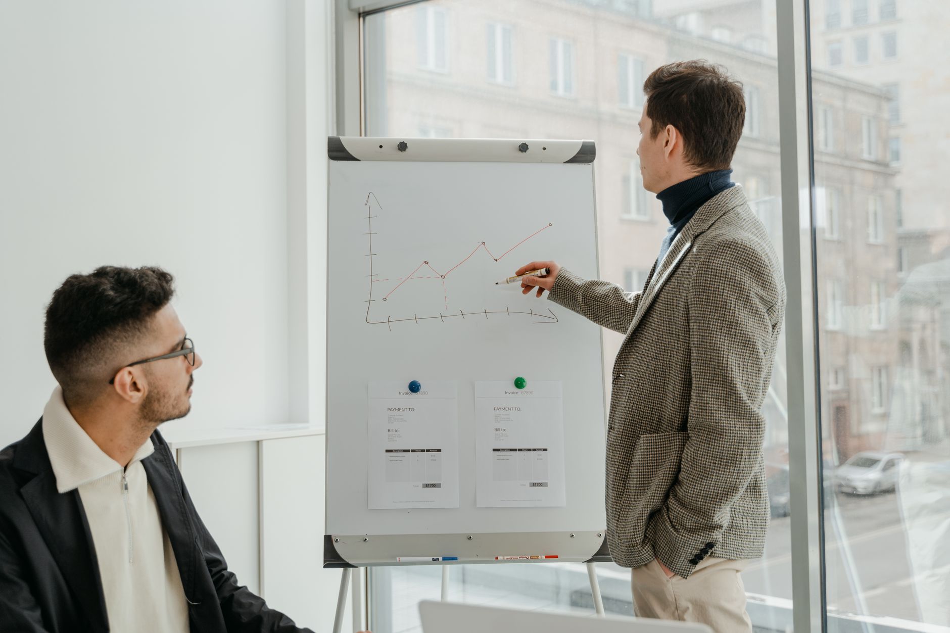 Two professionals examining graphs during an office presentation. — Harnessing the Power of HCG to Balance Testostero