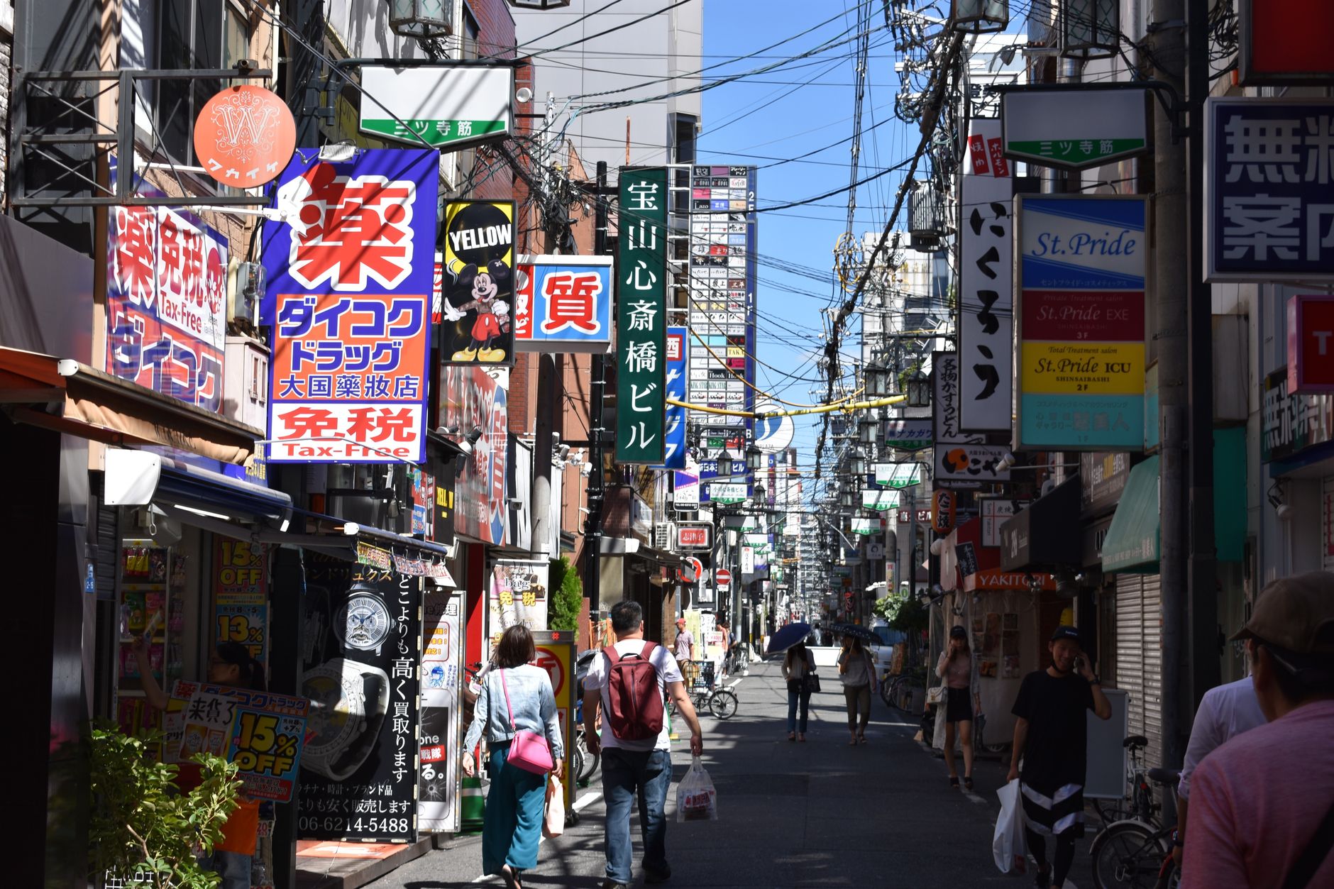 Bustling urban street in Osaka with colorful advertisements and pedestrians in daylight. — Preparing to Teach English