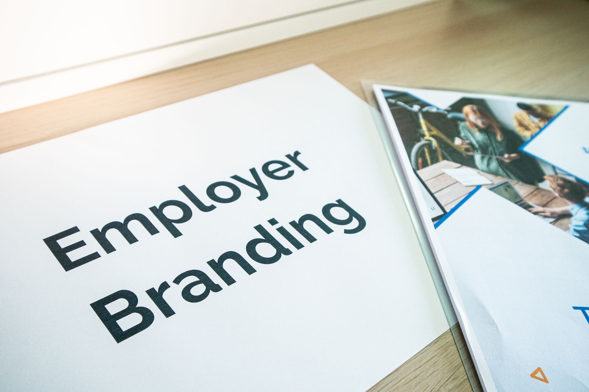 Focus on employer branding with documents on a wooden desk, ideal for business concepts. — Why Branding Is Essential for Smal