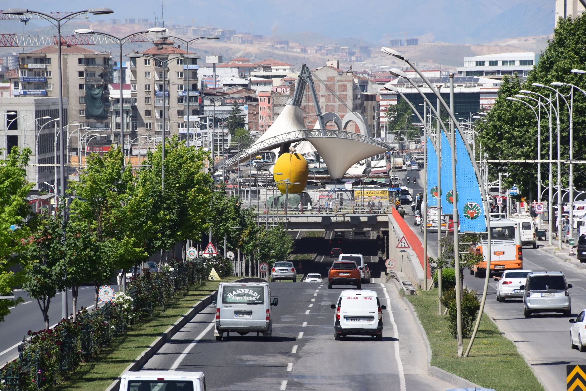 A bustling street scene in Malatya, Turkey featuring iconic apricot sculpture and cityscape. — Why is Dubai well suited for c